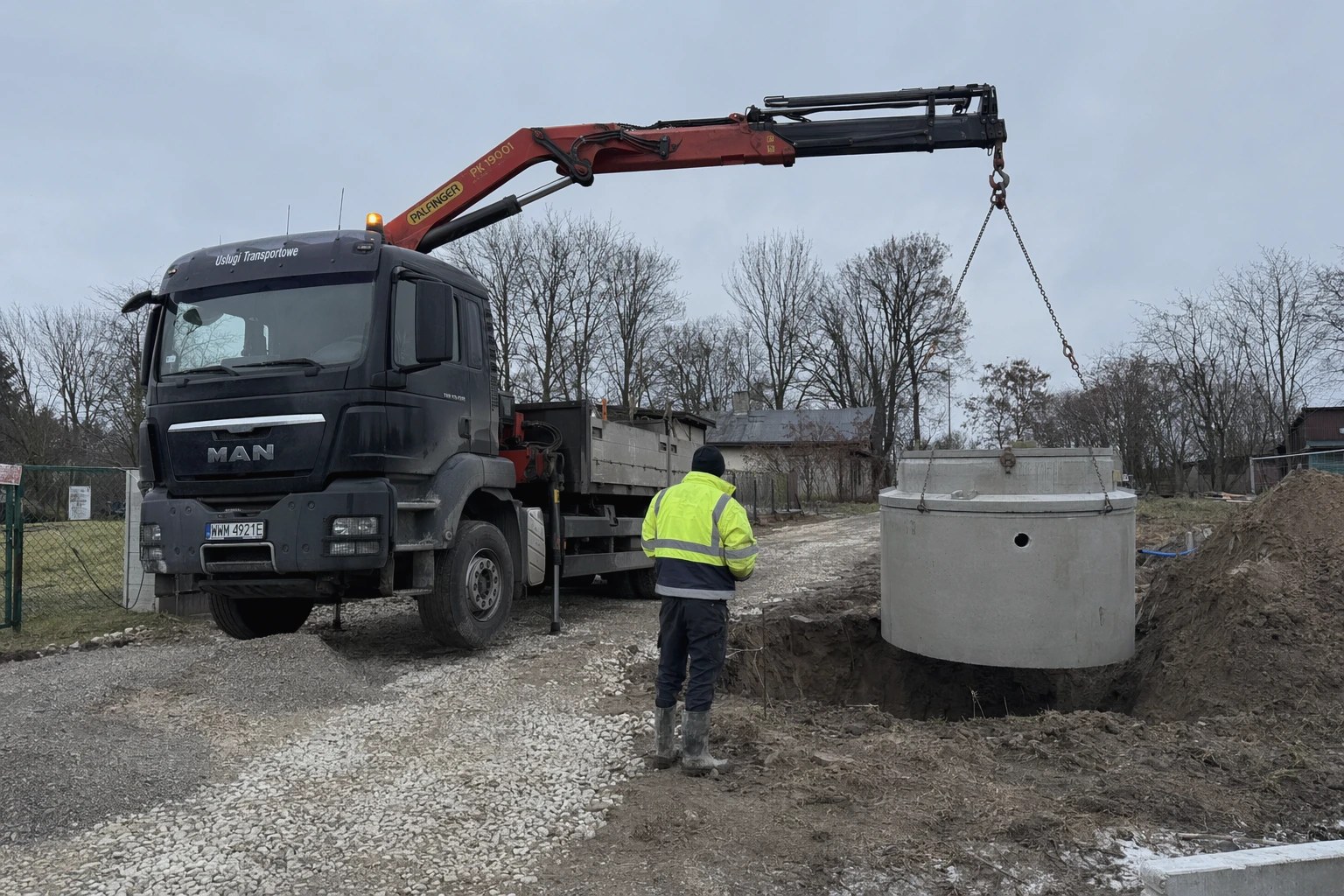 Rozładunek betonowego zbiornika dźwigiem HDS na działce
